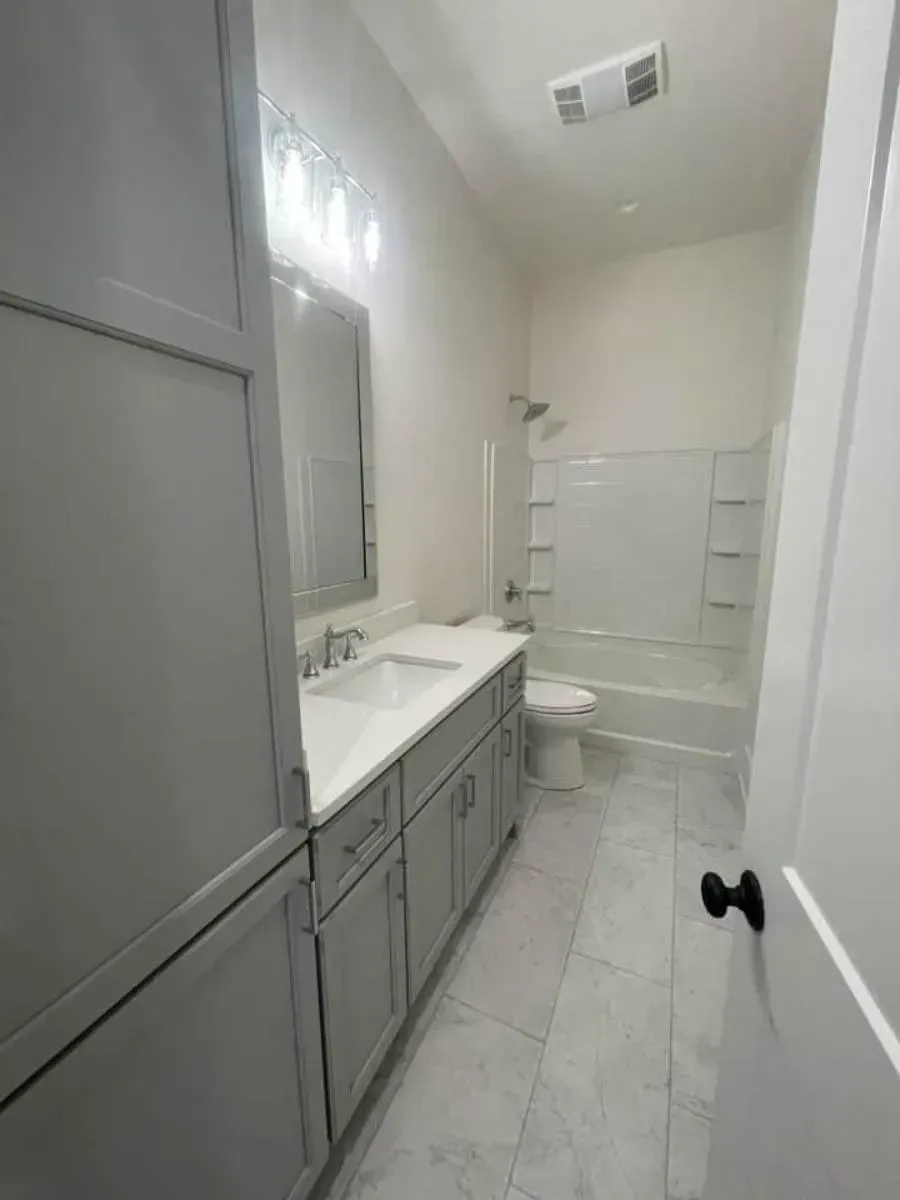 Bath 3 with a gray vanity, a white tub-shower and tile floors serving bedroom 4