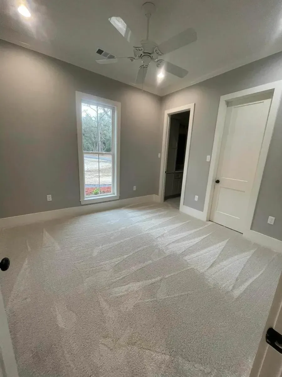 Secondary bedroom with carpet, a ceiling fan, a window and doors to the closet and hall