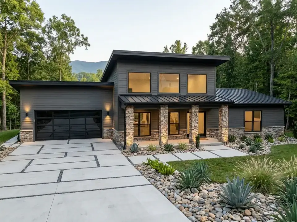 Desert Contemporary facade variant with dark grey horizontal siding sleek backdrop, stacked stone porch columns and foundation veneer, driveway of large concrete pavers with river rock bands, arid-climate planting beds with agave yucca and drought-tolerant plants
