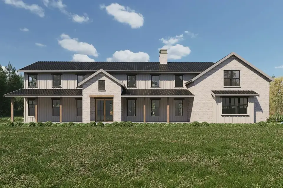 Dusk exterior view of the barndominium with interior glow through tall black-framed windows and a dark metal roof
