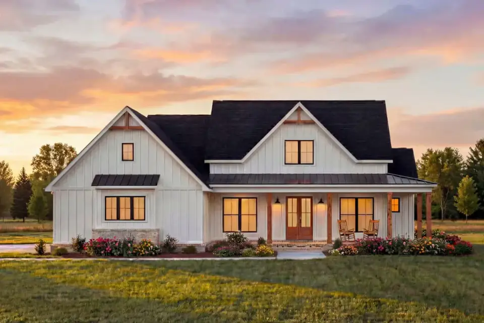 Angled view of the farmhouse exterior highlighting vertical board-and-batten siding and timber porch columns