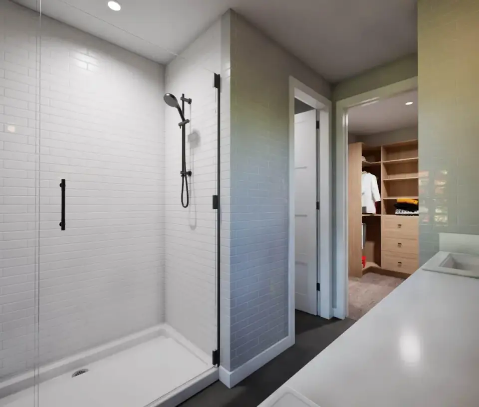 Master en-suite bath with a double wood vanity, large-format tile, and a glass-enclosed walk-in shower