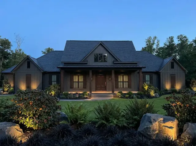 Sprawling Modern Farmhouse with Dark Siding at Dusk